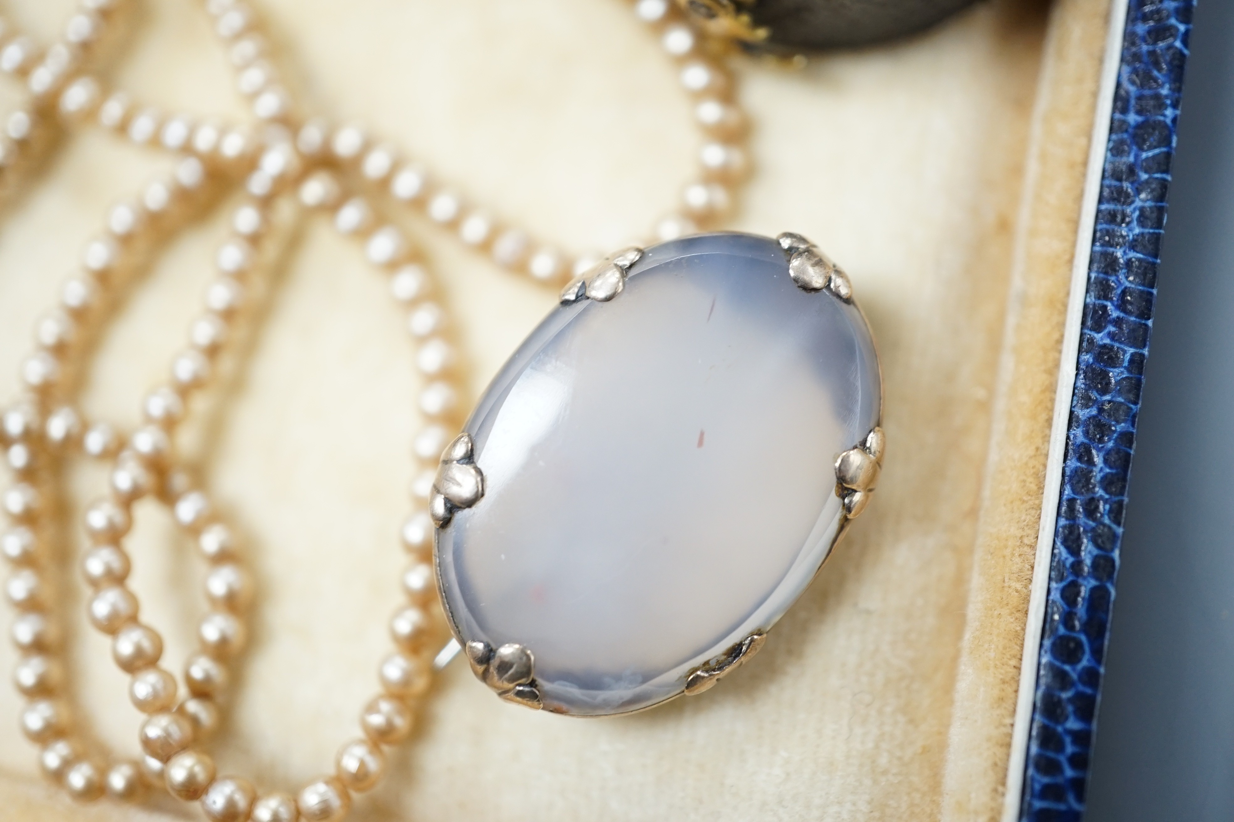 A simulated seed pearl necklace, oval brooch set with carnelian and a garnet set dress ring.